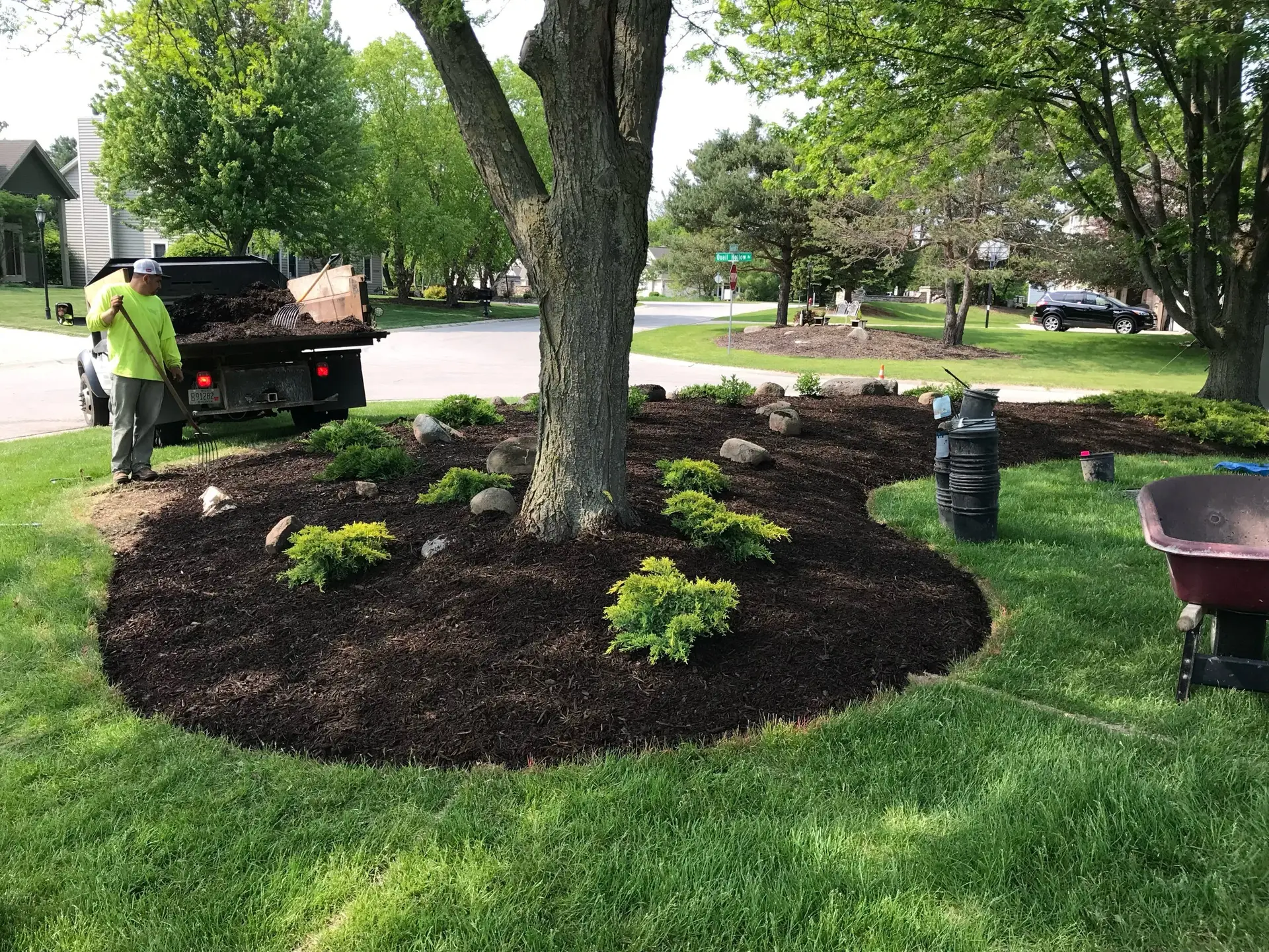 Freshly installed dark brown mulch around vibrant green plants in a Milwaukee residential landscape by Liban Landscape