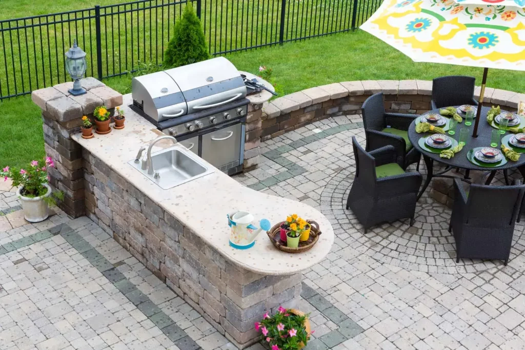 Custom Milwaukee outdoor living design featuring a built-in stone outdoor kitchen, paver patio installation, and dining area by Liban Landscaping.